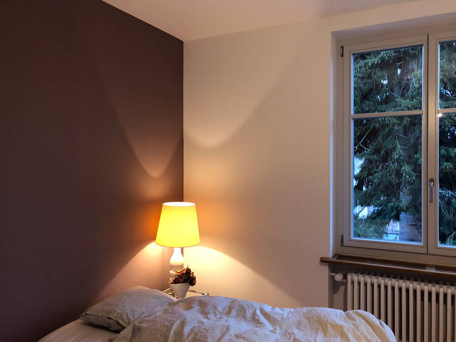 Schlafzimmer nach Feng Shui-Farbberatung. Eine dunkle Wandfarbe gibt Halt und Geborgenheit.